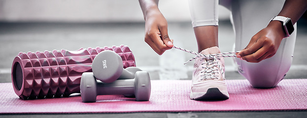 Image showing Fitness, weights and woman tying shoes before workout in gym for health, wellness and strength. Sports, training and closeup of athlete with laces to tie while preparing to exercise in a sport center