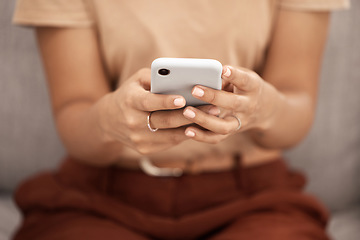 Image showing Phone, hands and woman texting closeup on a sofa, social media or online chatting in a living room. Zoom, hand and girl internet search, browsing or checking news update, meme or post in her home