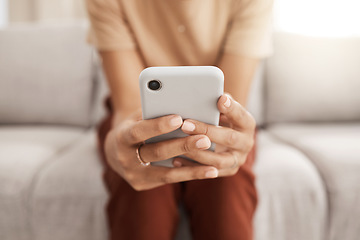 Image showing Hands, phone and communication with a black woman typing a text message or browsing social media in her home living room. Contact, mobile and networking with a female reading an email in the house