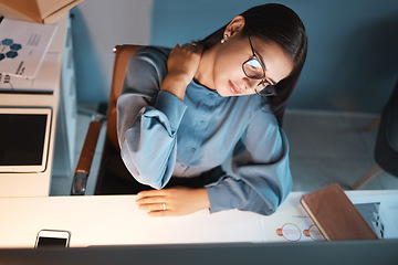 Image showing Woman, neck pain and night in office, working overtime and massage muscle, joint or body ache at desk. Businesswoman, burnout and tired with work injury while sitting at workplace table with stress