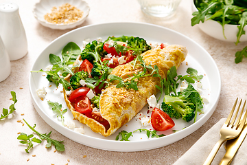 Image showing Omelette stuffed with tomato, broccoli feta cheese and fresh green salad. Healthy diet food for breakfast