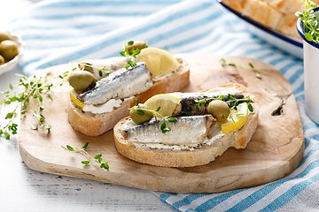 Image showing Sardines sandwiches on a white wooden background. Mediterranean food