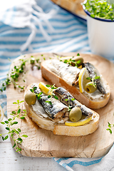 Image showing Sardines sandwiches on a white wooden background. Mediterranean food