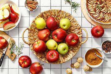 Image showing Apple. Fresh raw juicy red and green apples in a basket on a kitchen table with ingredients for cooking Thanksgiving autumn season apple pie, top view