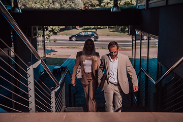 Image showing Modern business couple after a long day's work, walking together towards the comfort of their home, embodying the perfect blend of professional success and personal contentment.