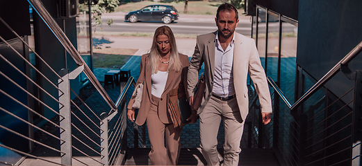 Image showing Modern business couple after a long day's work, walking together towards the comfort of their home, embodying the perfect blend of professional success and personal contentment.