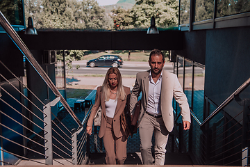 Image showing Modern business couple after a long day's work, walking together towards the comfort of their home, embodying the perfect blend of professional success and personal contentment.