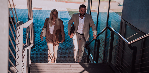 Image showing Modern business couple after a long day's work, walking together towards the comfort of their home, embodying the perfect blend of professional success and personal contentment.