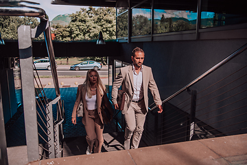 Image showing Modern business couple after a long day's work, walking together towards the comfort of their home, embodying the perfect blend of professional success and personal contentment.