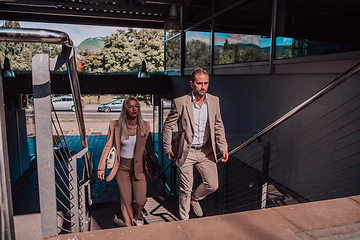 Image showing Modern business couple after a long day's work, walking together towards the comfort of their home, embodying the perfect blend of professional success and personal contentment.