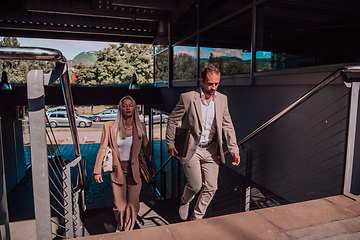 Image showing Modern business couple after a long day's work, walking together towards the comfort of their home, embodying the perfect blend of professional success and personal contentment.