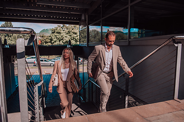 Image showing Modern business couple after a long day's work, walking together towards the comfort of their home, embodying the perfect blend of professional success and personal contentment.