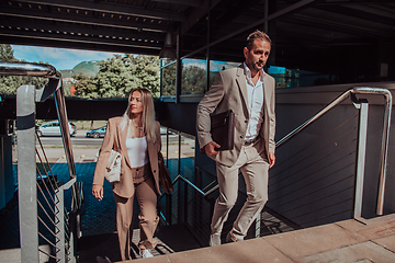 Image showing Modern business couple after a long day's work, walking together towards the comfort of their home, embodying the perfect blend of professional success and personal contentment.