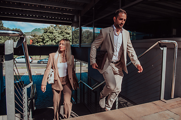 Image showing Modern business couple after a long day's work, walking together towards the comfort of their home, embodying the perfect blend of professional success and personal contentment.