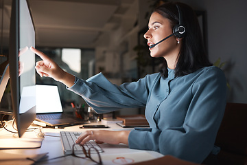 Image showing Call center, customer service and woman at night working in office, pointing at computer screen and helping client. Customer support, telemarketing and female consultant talking, speaking and online