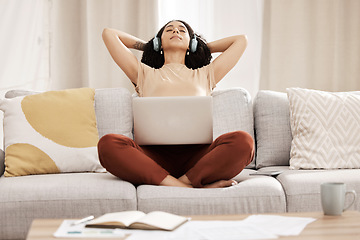 Image showing Black woman, headphones and laptop to relax, on couch for wellness and meditation in living room. Young female, girl and earphones for podcast, rest and on break for health, calm and peaceful on sofa