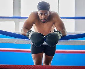 Image showing Boxing ring, man and tired from fight, training and workout in gym exercise, burnout and fail in competition games. Portrait sweating boxer, athlete and guy, break and breathing in sports arena club