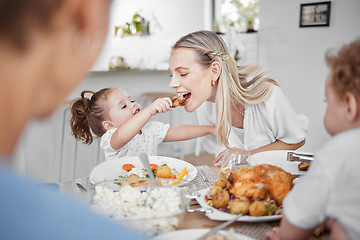 Image showing Happy family, mother and child eating chicken and vegetables in a healthy meal for dinner in Germany, Berlin. Food, nutrition and young girl feeding her hungry mom lunch at a home dining room table