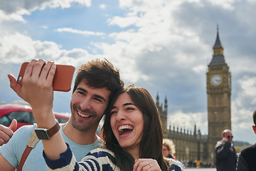 Image showing Travel, phone and couple take a selfie in London to post outdoor city street content on social media. Big ben, freedom and happy woman loves taking pictures with partner on a fun holiday adventure