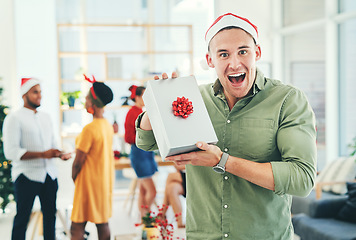 Image showing Wow, gift and businessman happy at a Christmas party for work celebration in the office. Smile, surprise and portrait of an excited employee with a present box at a professional company event