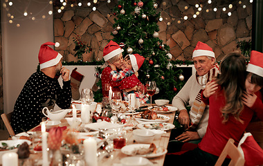Image showing Family, generations and Christmas dinner party with men, women and children smile, eat and drink together in dining room. Happy family, kids, couple and grandparents celebrate holiday hug at table.