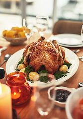 Image showing Thanksgiving, food and celebration with a turkey serving on a table in a home for tradition in the holidays. Christmas, chicken and eating with a meal served on a wooden surface from above for dining
