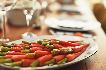 Image showing Thanksgiving, carrots and food with a plate of vegetables on a dinner table for tradition in an empty room. Roast, meal and nutrition with a lunch serving on a wooden surface in a house or home