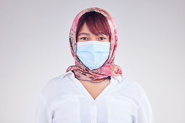 Image showing Covid, muslim and mask with a woman in studio on a gray background for health, safety or new normal. Face, portrait and Islam with a female wearing a hijab during the corona virus pandemic