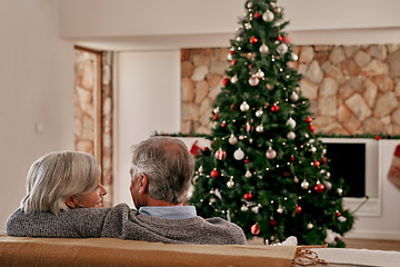 Image showing Elderly couple, hug and relax on sofa by Christmas tree for relationship bonding or quality time together at home. Senior man holding woman on living room couch for holiday, vacation or new year