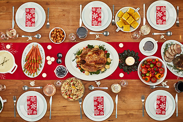 Image showing Christmas, party and food with a festive feast on a dinner table in a home from above for celebration. Chicken, event and nutrition with a meal setting on a wooden surface in the holiday season