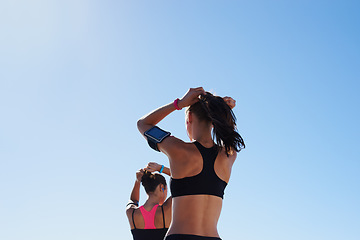 Image showing Fitness women, blue sky background and hair tie for cardio exercise, running workout and summer wellness. Healthy female runners, sports athlete and friends prepare for morning training on sky mockup