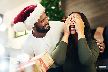 Image showing Christmas surprise, gift and couple in home with husband and wife having fun and bonding on holiday. Xmas, love and woman with eyes closed receiving box of presents from man for festive celebration.