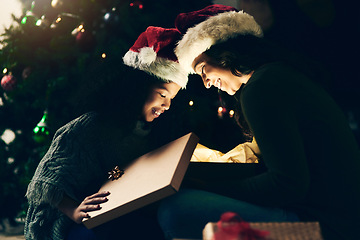 Image showing Christmas, holiday and mother and girl with present opening magic gift box together for festive tradition. Family, love and mom with child on festival, celebration and vacation by Christmas tree