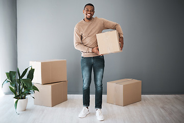 Image showing Black man, moving and home portrait with box excited for real estate, property and new house. Boxes, happy and smile of home owner standing with cardboard boxes at gray wall advertising mockup.