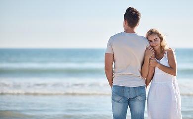 Image showing Love, peace and couple at a beach to relax on holiday, vacation or weekend in a summer romance together. Travel, freedom and happy woman enjoys hugging her partner with affection in nature or ocean