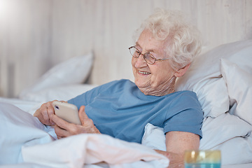 Image showing Phone, bed and social media with a senior woman typing a text message while in the bedroom to relax. Contact, communication and mobile with a mature female reading or texting alone in the house