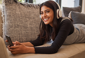 Image showing Woman, happy and headphone phone music of a person listening to a podcast or video watching at home. Portrait of an indian person with happiness and smile about mobile technology on living room sofa