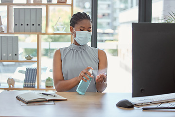 Image showing Covid, mask and hand sanitizer with a business black woman cleaning while working in her office. Health, safety and sanitizing with a female employee using disinfectant during the corona virus