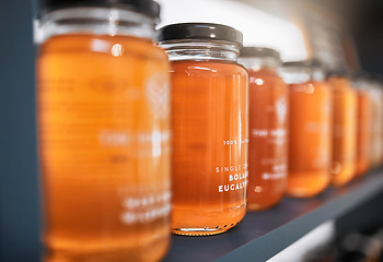 Image showing Honey, product and retail with shelf of store for food, supermarket and grocery shopping with nobody. Organic, natural and glass of gold liquid ingredient for vegan, healthy and wellness lifestyle