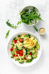 Image showing Couscous salad with broccoli, green peas, tomatoes, avocado and fresh arugula. Healthy natural plant based vegetarian food for lunch, israeli cuisine, top view