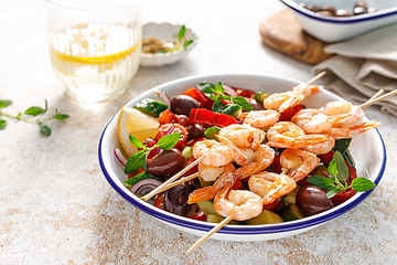 Image showing Shrimp kebab roasted on skewers and fresh vegetable salad