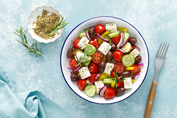 Image showing Greek salad. Vegetable salad with feta cheese, tomato, olives, cucumber, red onion and olive oil. Healthy vegetarian mediterranean diet food. Top view