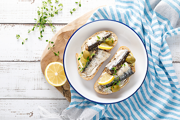 Image showing Sardines sandwiches on a white wooden background. Mediterranean food. Top view