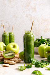 Image showing Smoothie. Healthy fresh raw detox spinach smoothie with green apple, kiwi and ginger in a bottles on a table. Healthy diet vegan food full of antioxidants
