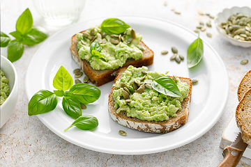 Image showing Avocado sandwich with pumpkin seeds. Healthy vegetarian avocado toast with rye bread for breakfast. Vegan menu