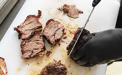 Image showing Chef hands slicing beef steak