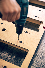 Image showing Man is working with electric screwdriver