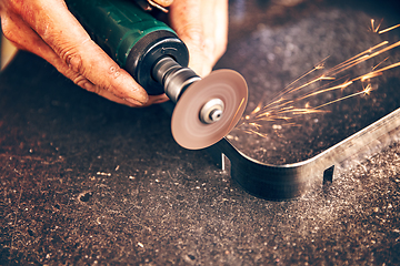 Image showing Worker cuts metal with metal sawing