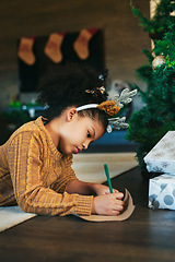 Image showing Christmas, celebrate and girl writing in a card, list or letter for holiday on the living room floor. Idea, wish and child with paper for a gift, note or drawing during xmas celebration in a house