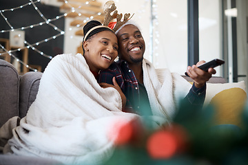 Image showing Christmas, comfort and African couple watching tv, news or a movie from the living room sofa. Television, relax and black man and woman on the couch for a film on a subscription service for festive